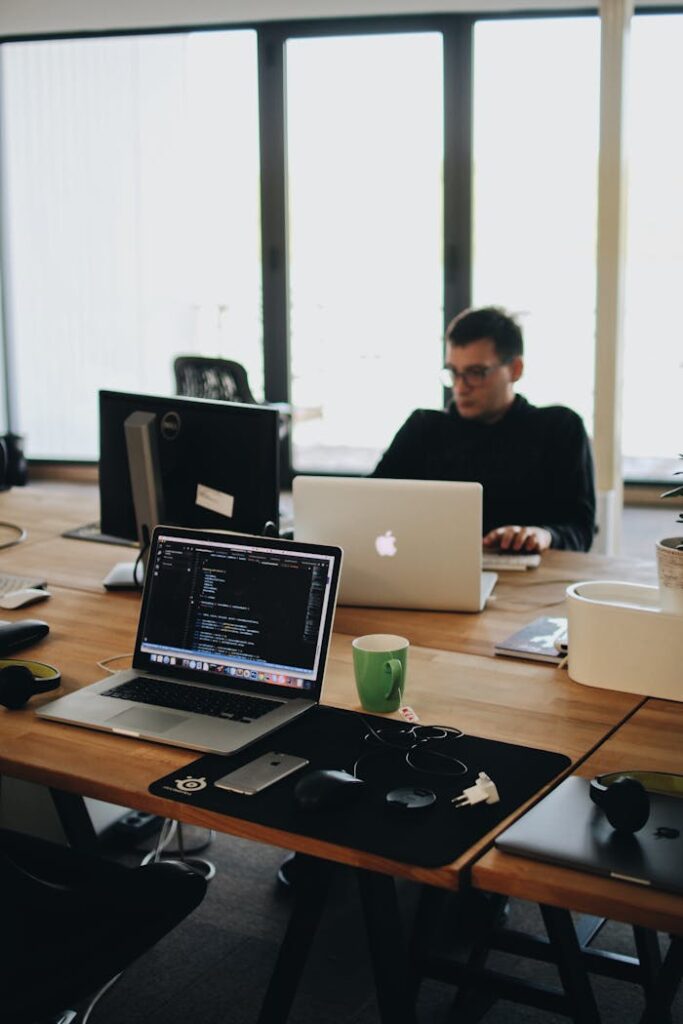 pexels-photo-2102416 A web developer working on code in a modern office setting with multiple devices.