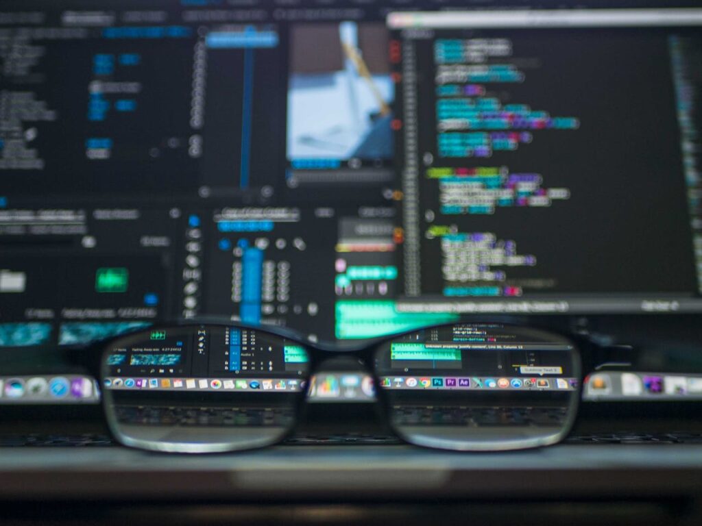 pexels-photo-577585 Eyeglasses reflecting computer code on a monitor, ideal for technology and programming themes.